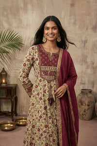 Woman in red and cream kurti set in a warm-toned room.