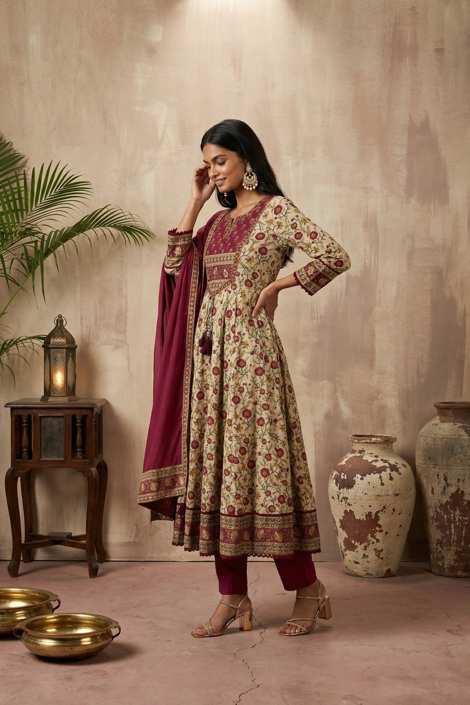 Woman in red and cream kurti set in a warm-toned room.