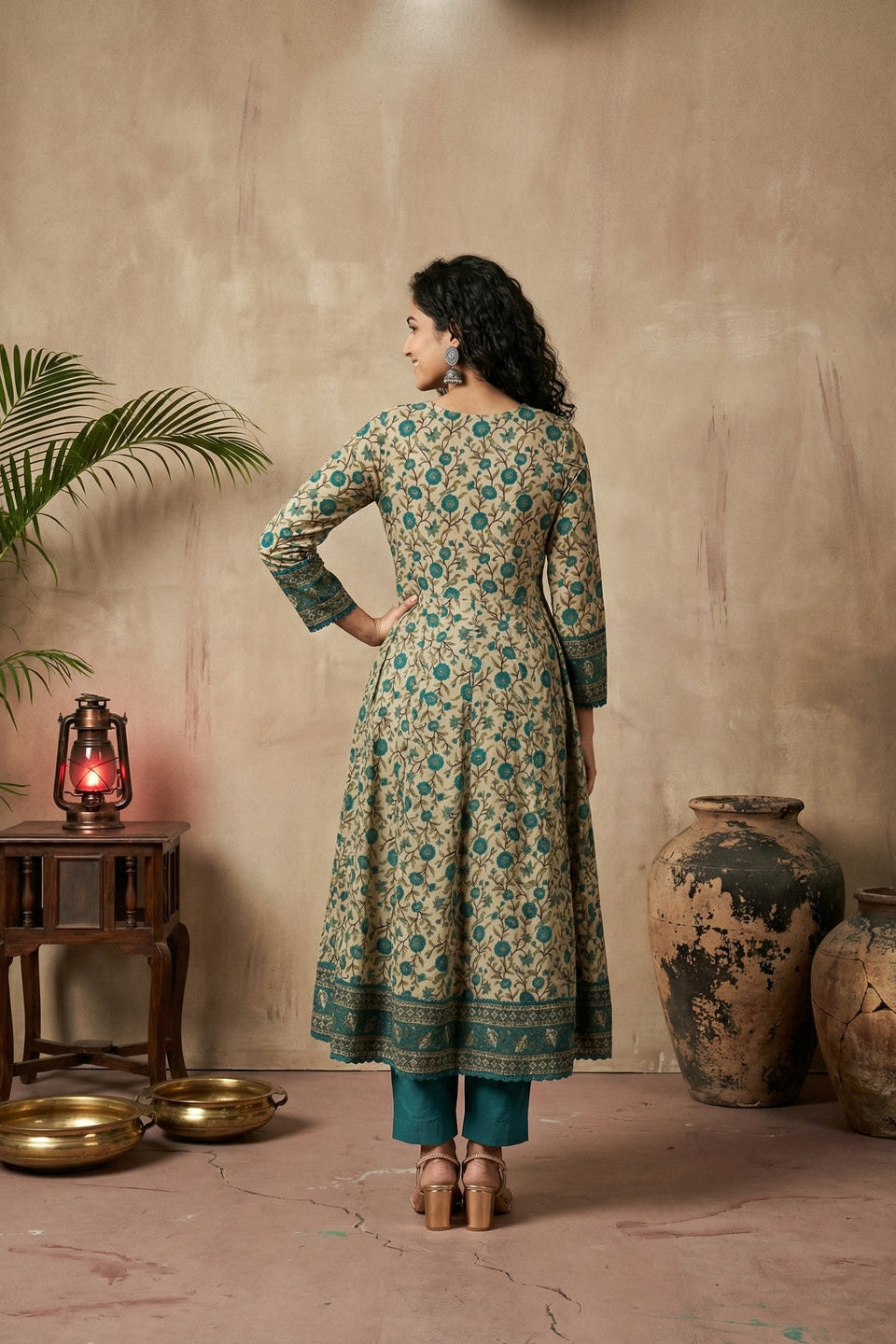 Woman in a floral dress standing in a room with rustic decor elements.