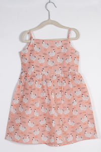 peach dress with chicken pattern on a hanger against a white background