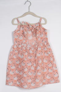 peach dress with chicken pattern on a hanger against a white background