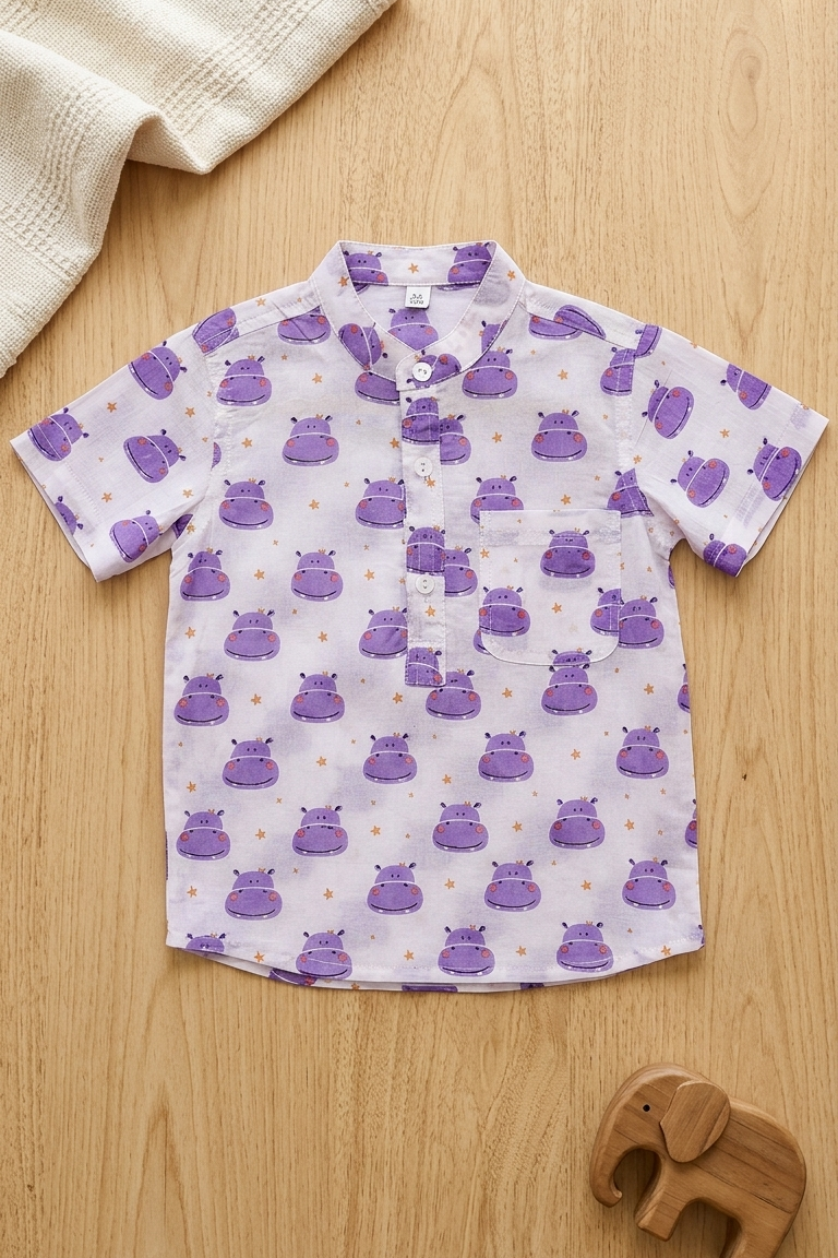 Children's shirt with purple hippo pattern on a wooden surface