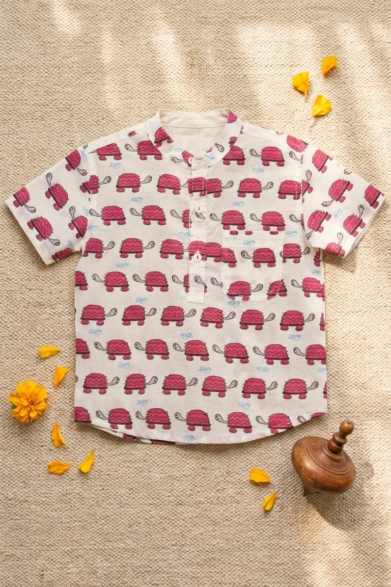 Children's t-shirt with red turtle pattern on a beige fabric background