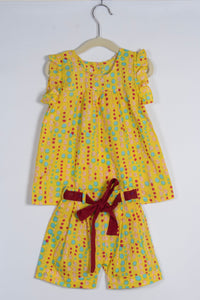 Yellow polka dot dress with a red belt on a white background